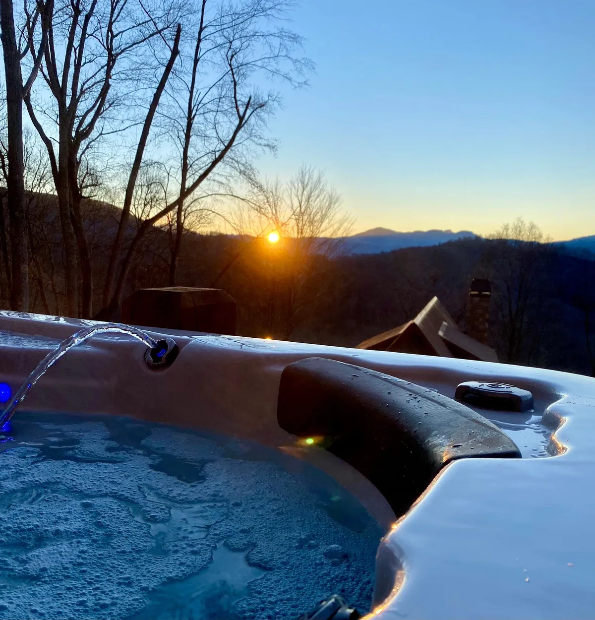 Featuring a hot tub with direct sightlines to a sweeping mountain range at sunset, this image is all about tranquil luxury. The sky glows with warm colors, while the hot tub offers the perfect vantage point for stargazing or evening relaxation.